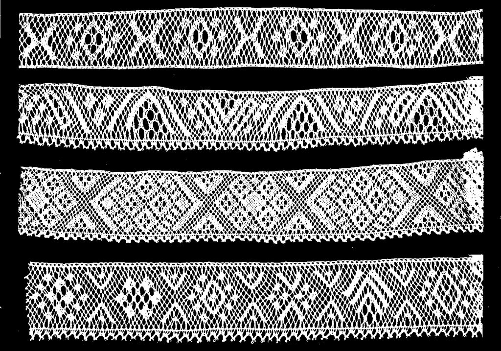 fyra vita spetsar med olika mönster på svart botten